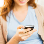 close up of woman texting on smartphone at home